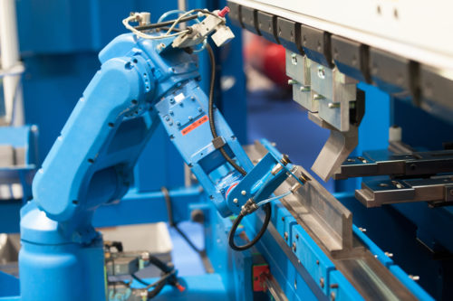 blue machine tending robot arm moving components